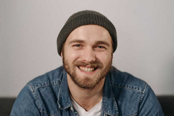 a bearded man with a beanie posing for a photo