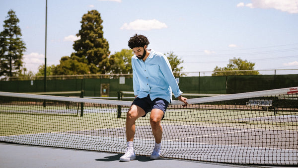a man with a healthy beard playing tennis