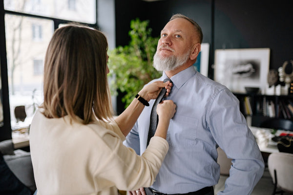 a man with a long beard buttoning up his shirt