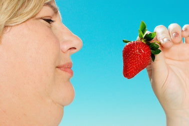 Woman holding a strawberry - Belkyra Calgary