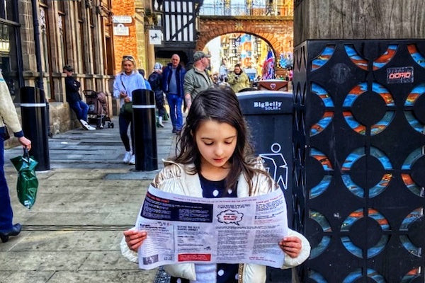 Girl using treasure map in busy town centre
