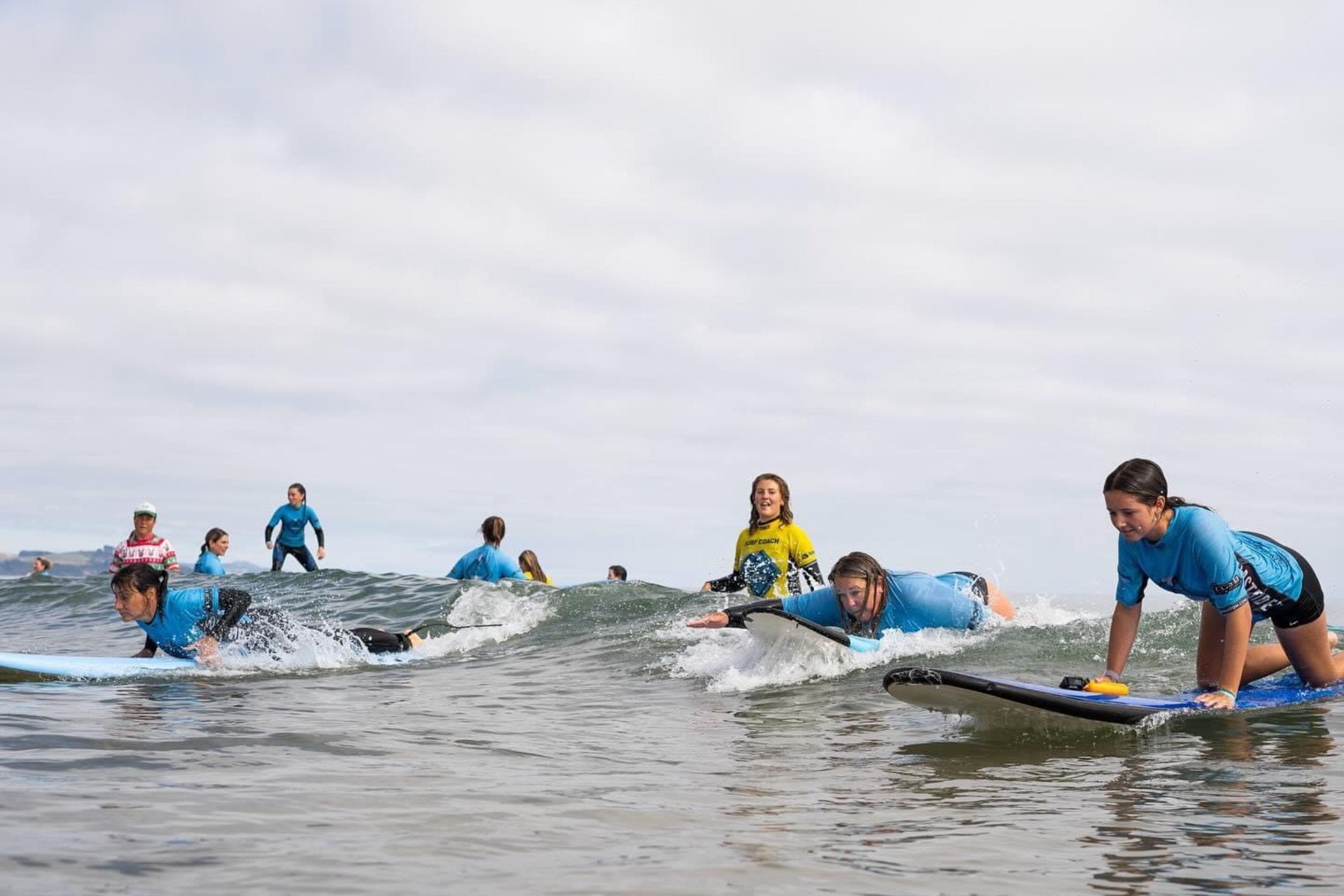 A group of young Tasmanian women on surboards in the ocean