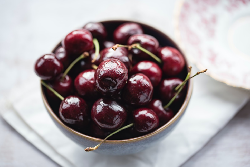 bowl of red pitted cherries with stems