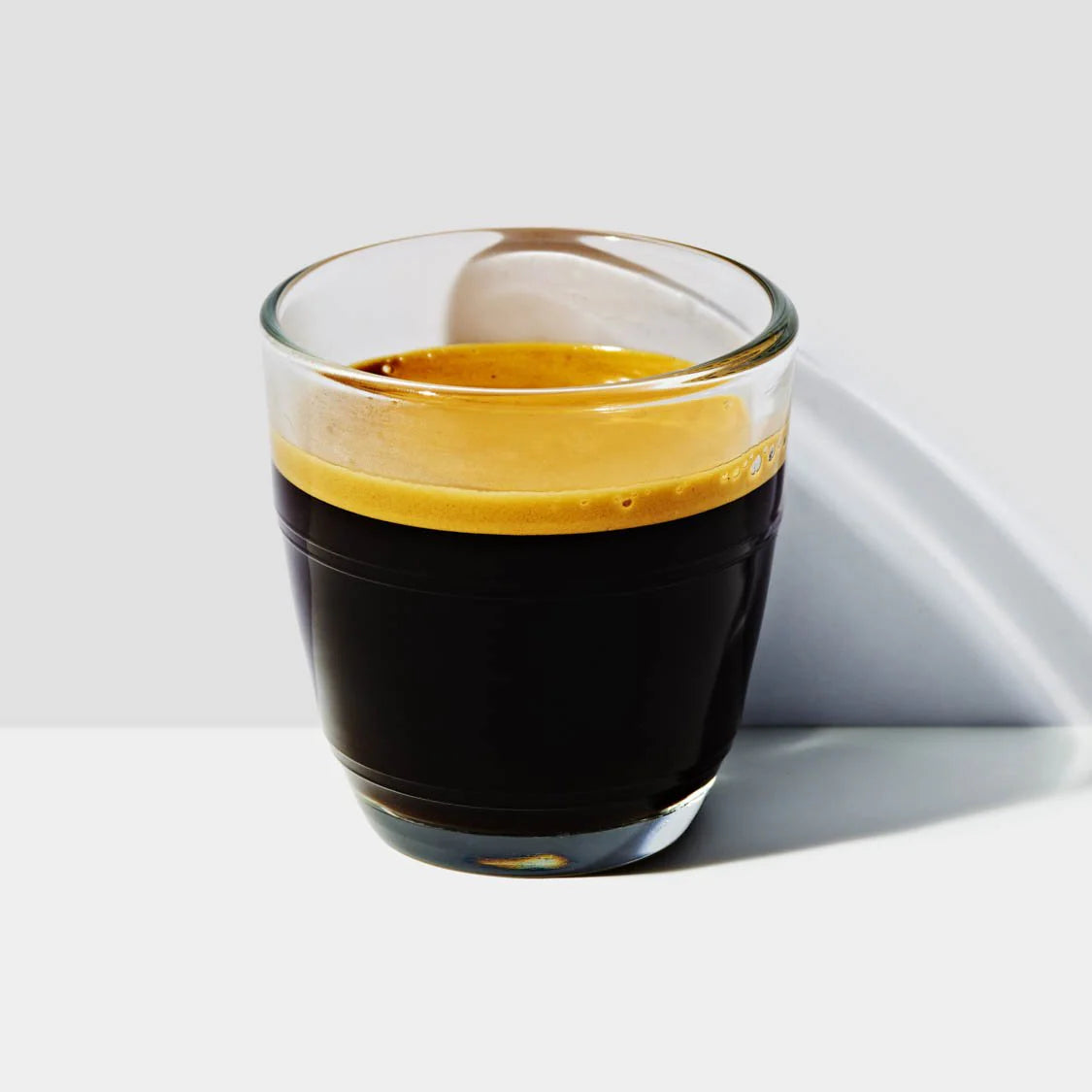 A glass of espresso with a rich crema on top.