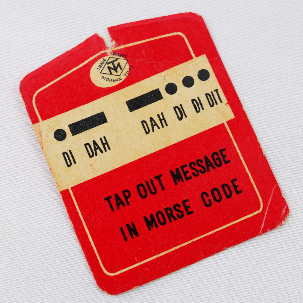 Red and white paper tag with morse code message in black and the instructions "tap out message in morse code".
