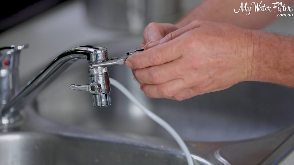 Using a tool to tighten the water filter diverter