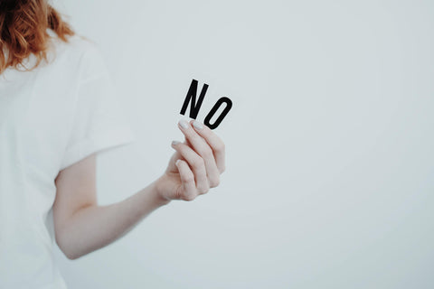 Girl holding a sign that says no