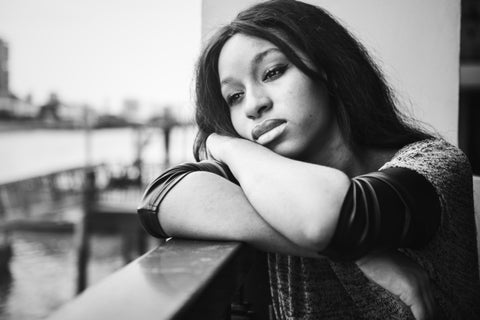 A young woman who appears to be very sad in this black and white photo.