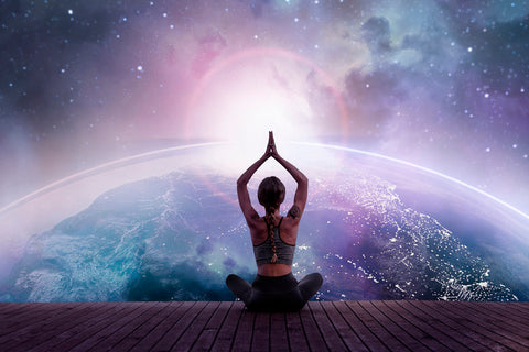 Woman in yoga pose against a cosmic background.