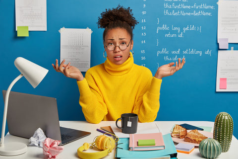 Young woman at work with hands in the air in frustration