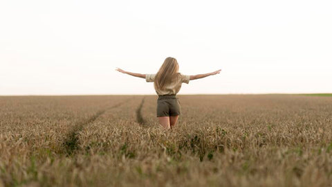 Women with her arms extended to the open sky.