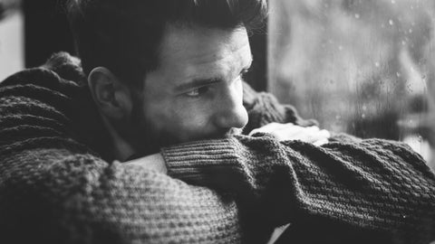 A young man deep in contemplation in this black and white photo.