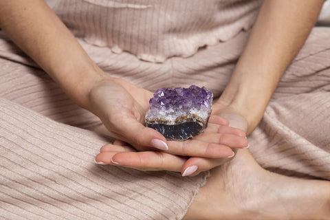 Woman using amethyst crystals for meditation purposes.