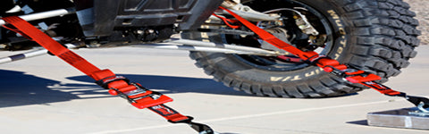 Tie down straps hooked to a utv and trailer