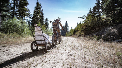 Man Hauling Harvested Game on an eBike Cargo Trailer being hauled behind a Bakcou eBike - Bakcou Folding Deer Trailer