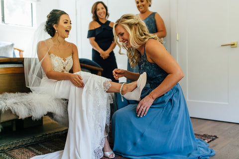 Bridesmaids helping bride get ready