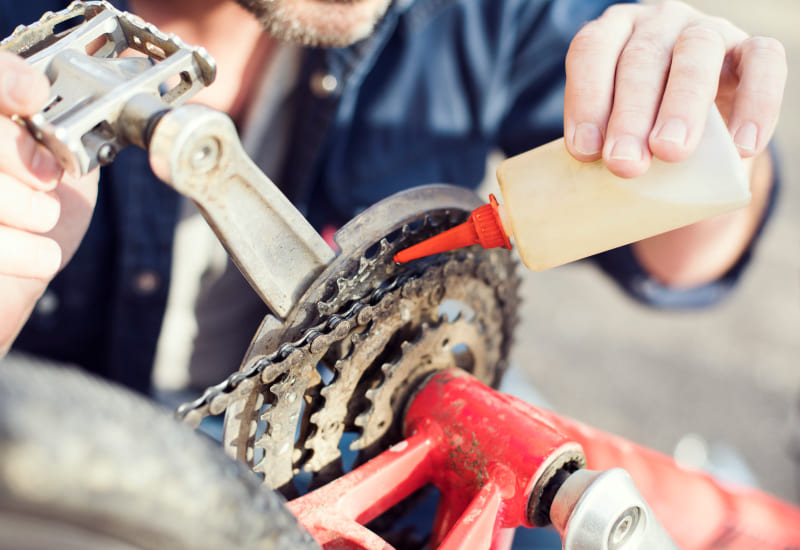 man oiling chain on bike