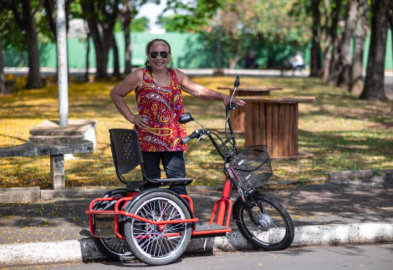 older woman next to an electric tricycle