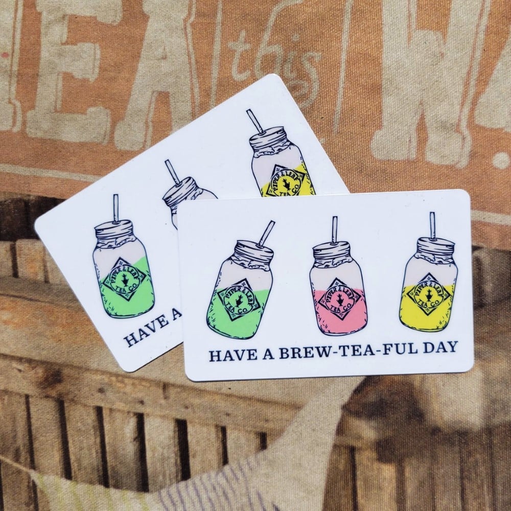 A Piper and Leaf gift card with 3 Piper and Leaf quart jars filled with vibrant Piper and Leaf tea reading "HAVE A BREW-TEA-FUL DAY" on it