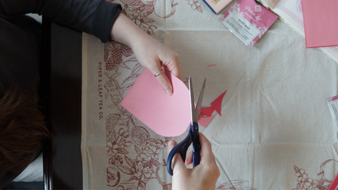 Piper and Leaf crafter rounding off paper edges for a DIY galentine valentine craft