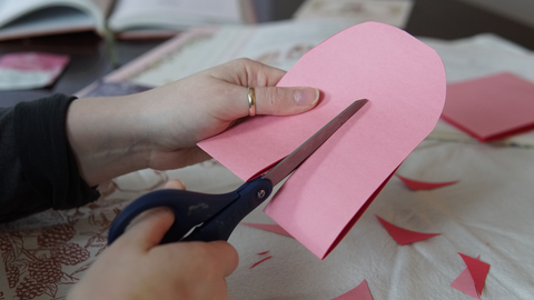 Piper and Leaf crafter cutting rounded paper through the middle for a galentine valentine DIY craft