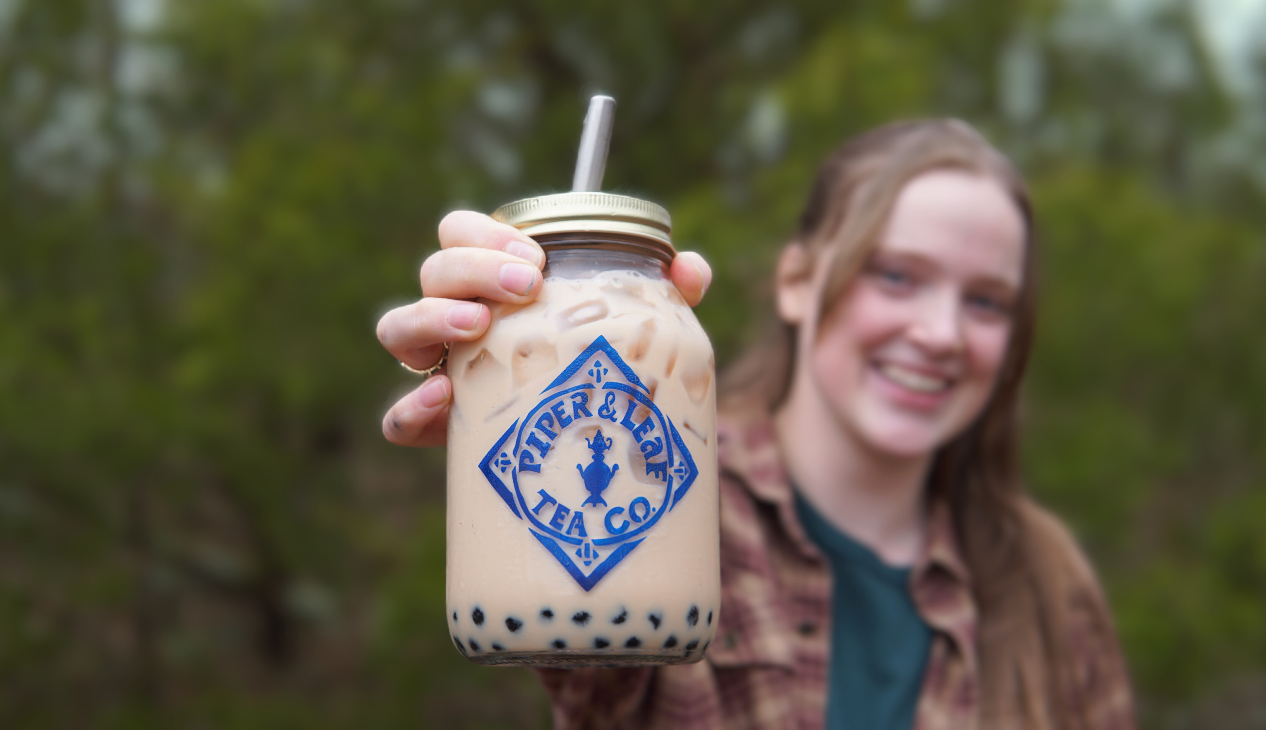 a girl holding a jar of Piper and Leaf iced bubble tea