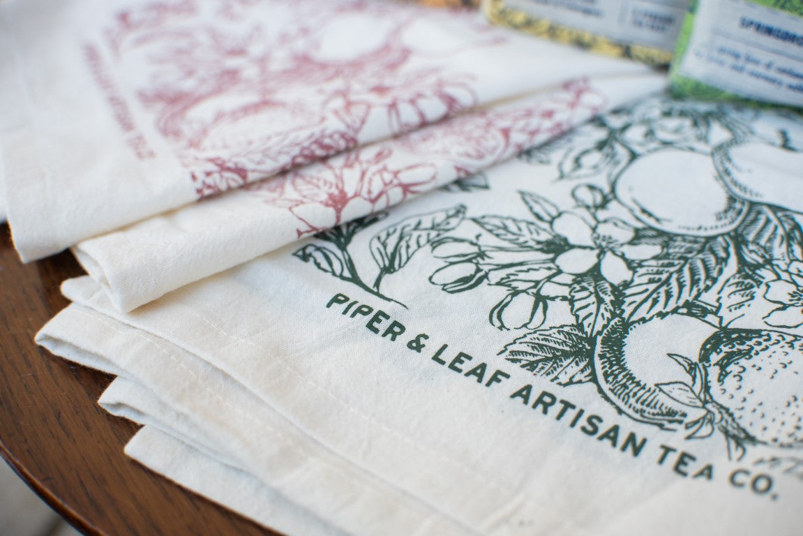 Green and Pink elegant Piper and Leaf tea towels laid flat to display their fruity and floral beauty