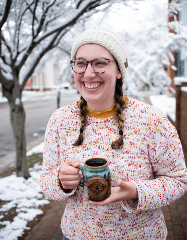 girl holding a handmade piper and leaf pottery mug of hot sweetie pie chai specialty winter dink