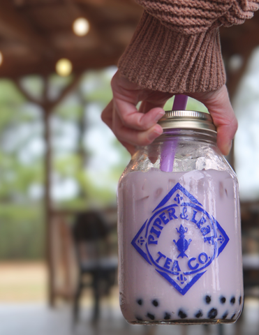 a girl holding a jar of Piper and Leaf iced boba tea