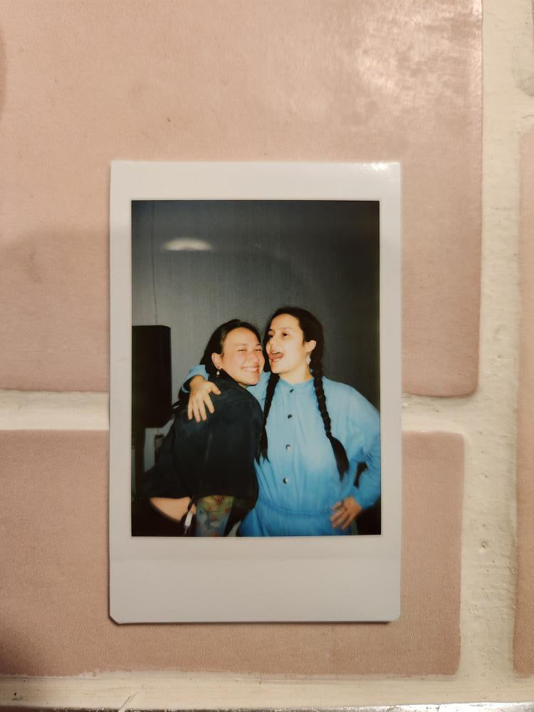 A polaroid photo features two guests at the event smiling