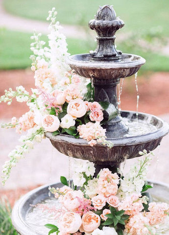 Fountain decorated with pink flowers and with water running