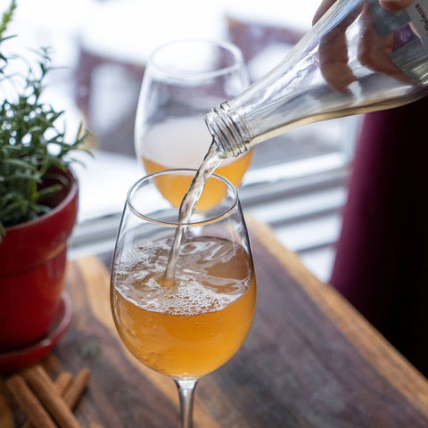 Pouring Goodmore Kombucha into Wine Glass