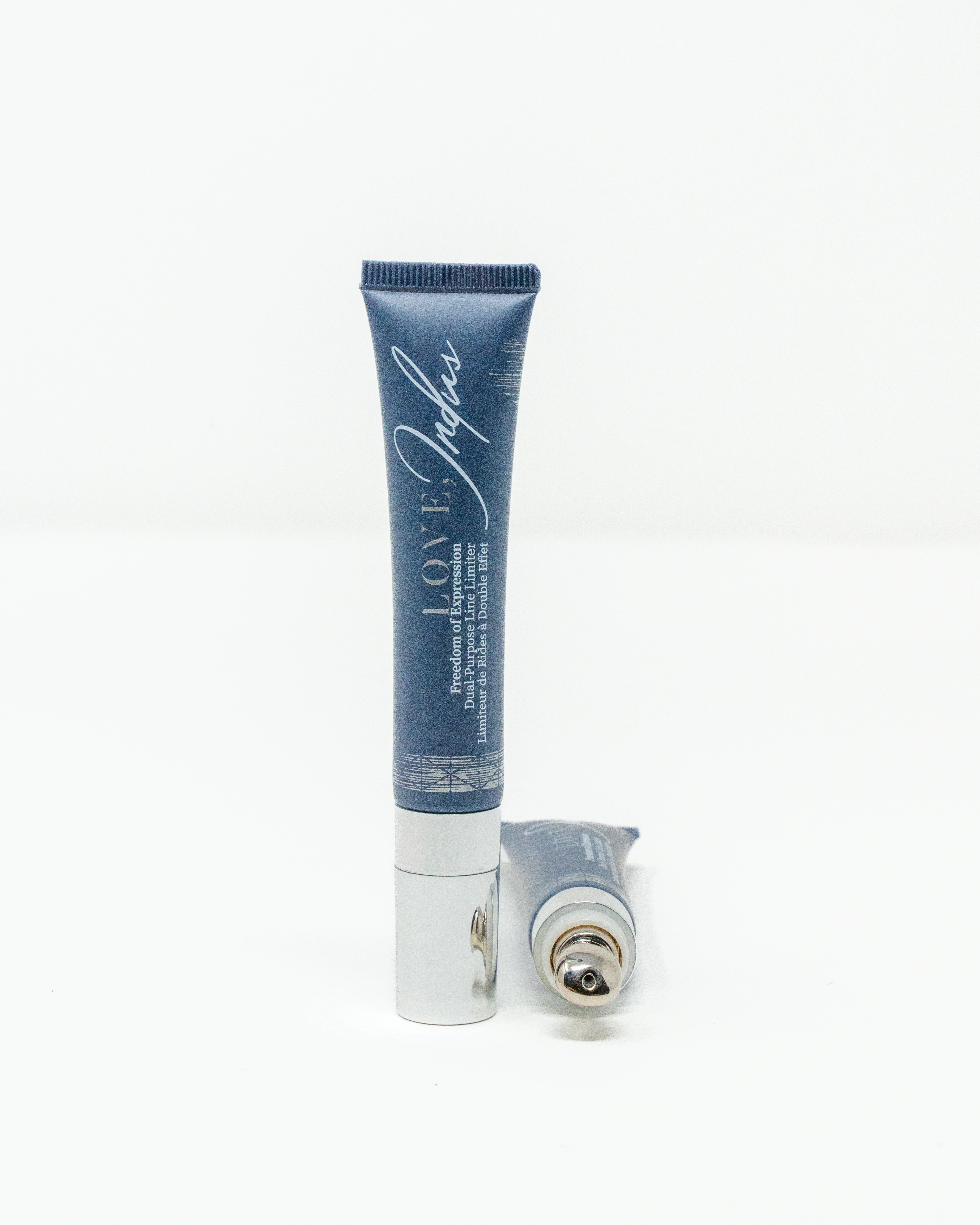 Two blue cosmetic tubes with silver caps, one standing and the other lying down.