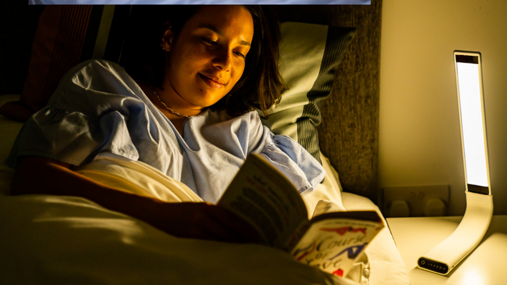 woman reading in bed with blue light lamp as light source