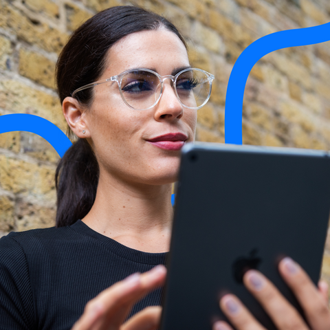 woman using ipad wearing blue light glasses