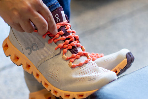 coral color shoelaces paired with On Running Shoes