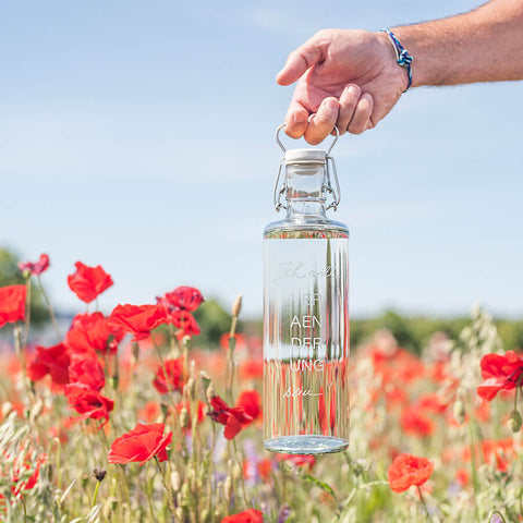 Glasflasche im Blumenfeld