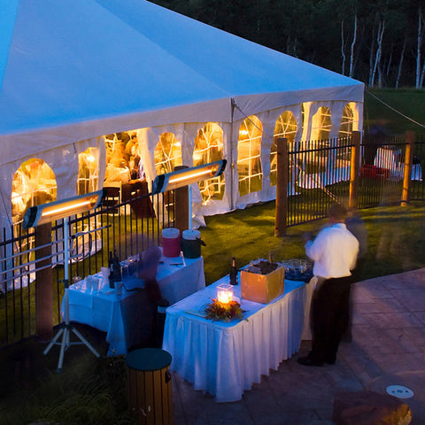 An outdoor party with decorations displayed along with two KMH-2500R 2.5KW Free Standing Infrared Heaters set up.