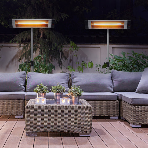 An outdoor seating space with furniture and two KMH-3000R 3KW Free Standing Infrared Heaters