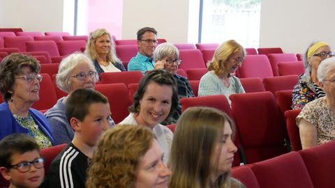 Lady in an audience smiling at the camera