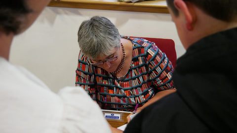 Lady in a book design dress signing books