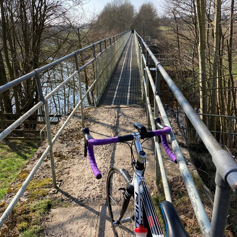 Narrow metal bridge with cycle waiting to cross