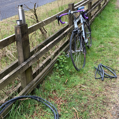 Bike resting on fence and a flask of tea