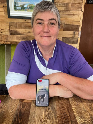 Woman in a purple top with a mobile phone in front of her