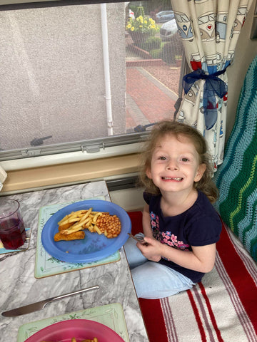 Girl eating a meal in a campervan