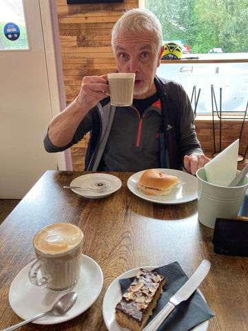 Man drinking a coffee and eating a sandwich