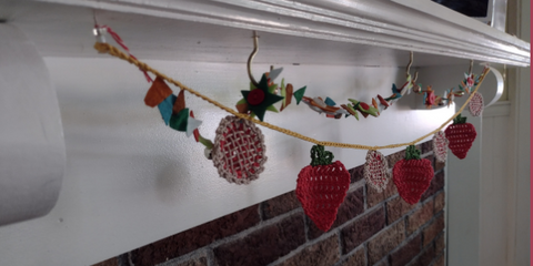 Strawberry Pie garland under a mantle | One Big Happy Yarn Co