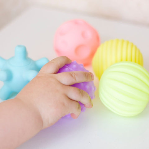 Balle sensorielle pour bébé conçue pour stimuler les sens de bébé avec des couleurs vives, des textures différentes et des sons amusants