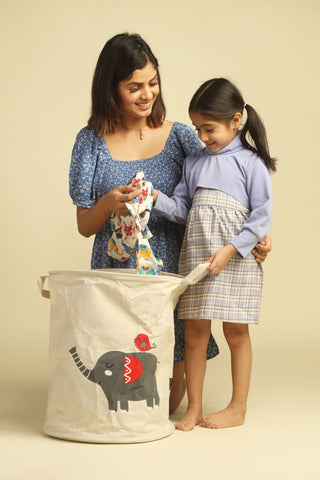 mom and baby girl putting clothes in polka tots laundry bag