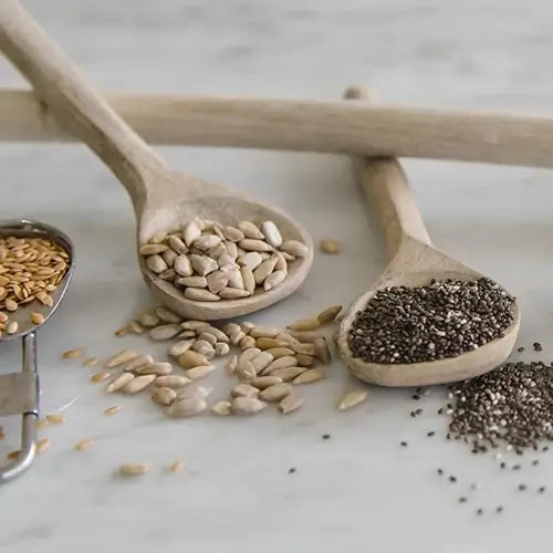 Wooden spoons filled with sunflower kernels and chia seeds